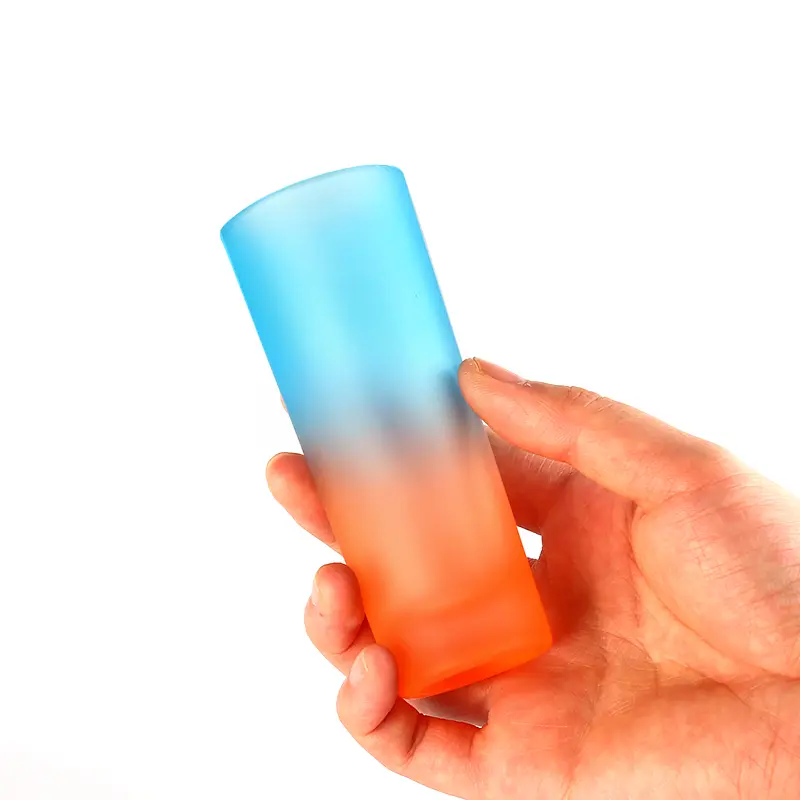 shot-glass-size-reference Colored frosted shot glass held in hand for size reference
