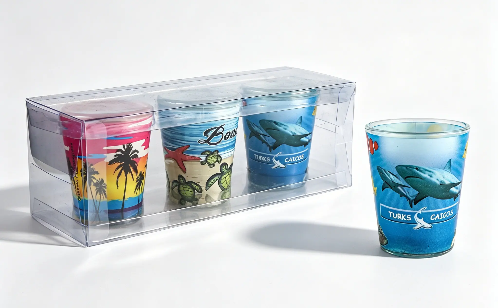 Custom 3-piece shot glass set packaged in a clear transparent gift box, featuring vibrant tropical beach and ocean print designs.