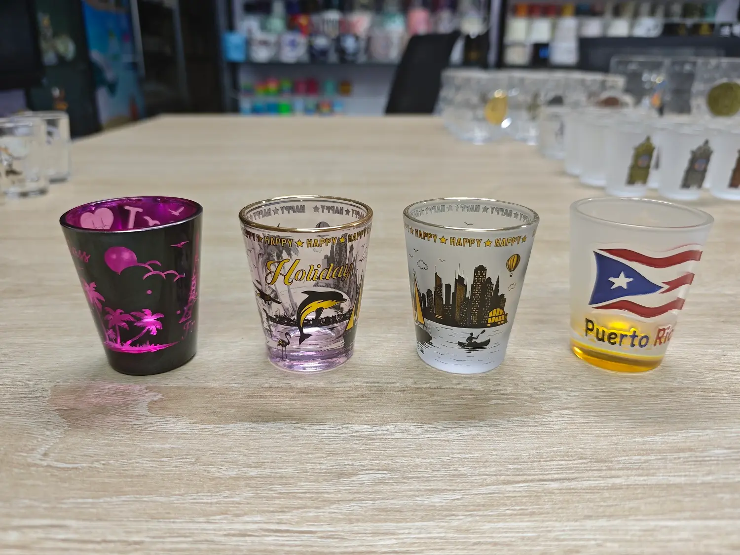 Custom souvenir shot glass samples showing various design styles and printing techniques for bulk B2B orders.